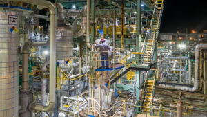 OQ Chemical, a chemical company, employee climbs tower to perform maintenance beneath Dialight SafeSite Area Lights.